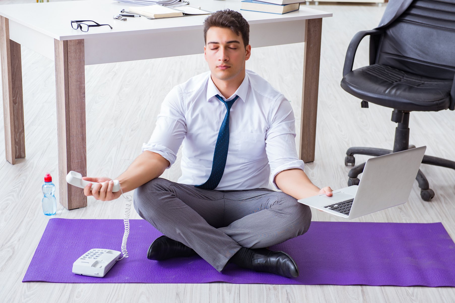 Man Meditating in the Office to Cope with Stress